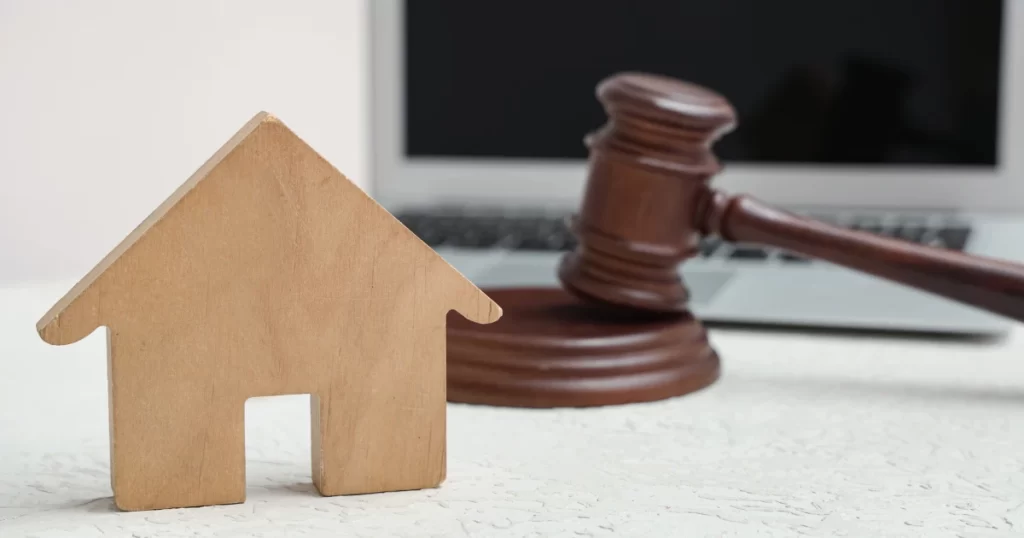 土地代標公司服務示意，房屋模型與法槌代表不動產代標流程