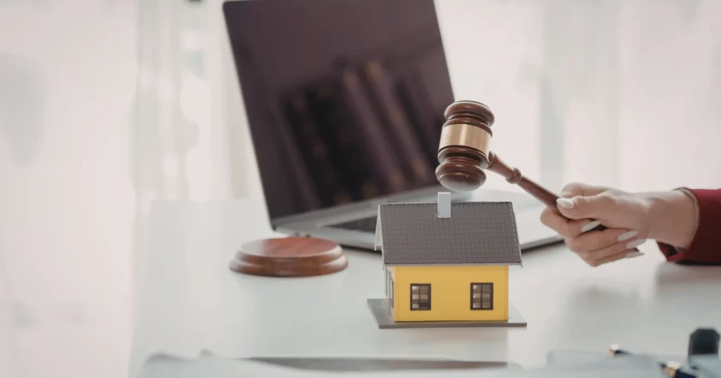 土地代標違法風險示意，法槌與房屋模型象徵法律與不動產糾紛